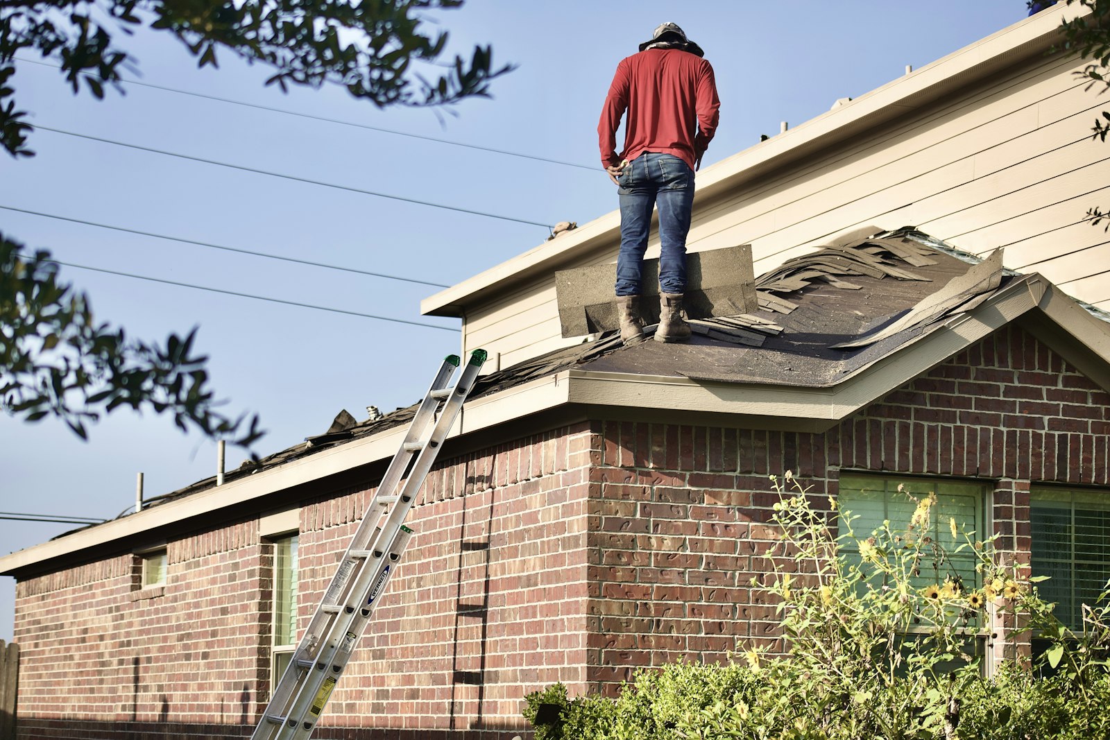 Roofer replacing shingles on a house